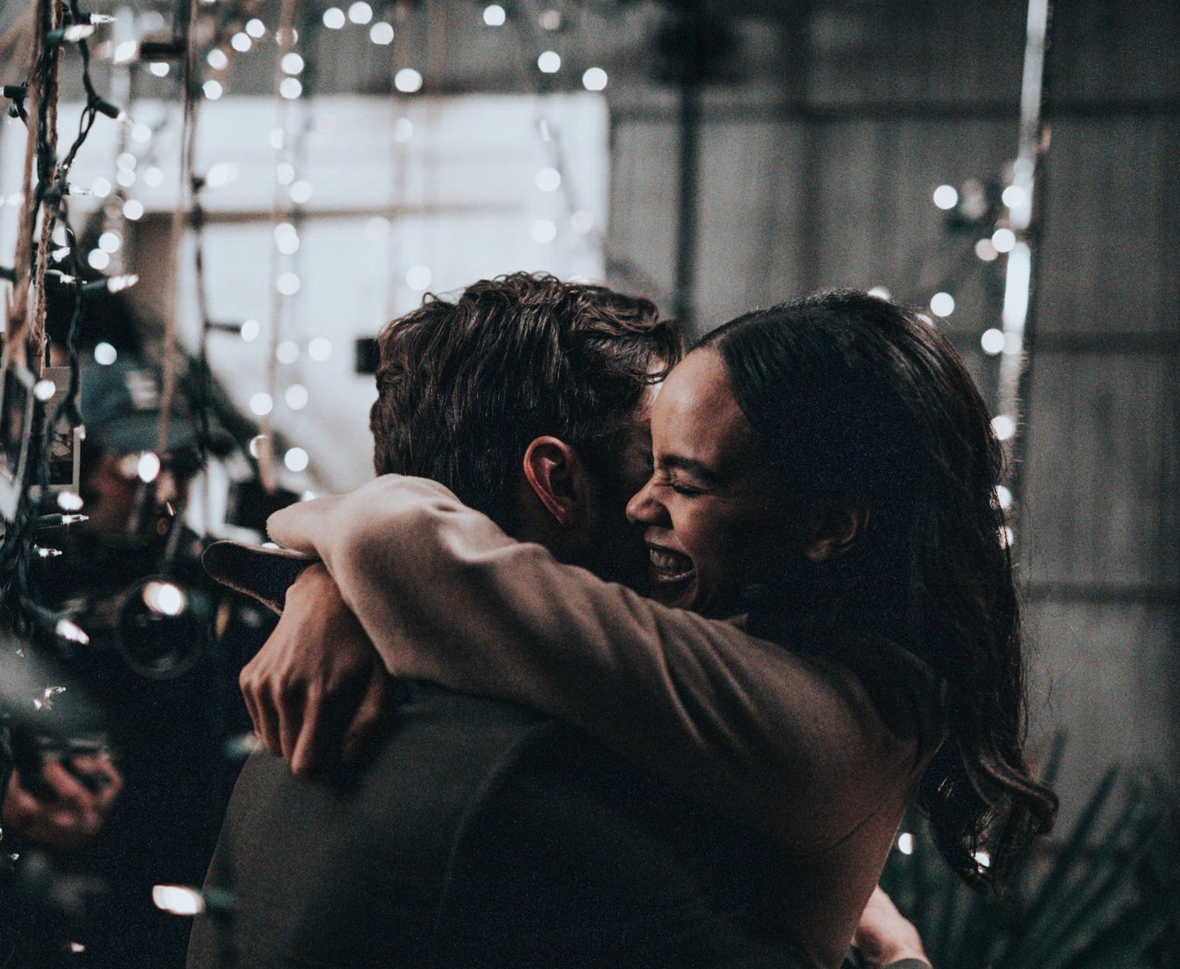 Couple sharing a hug under sparkly lights