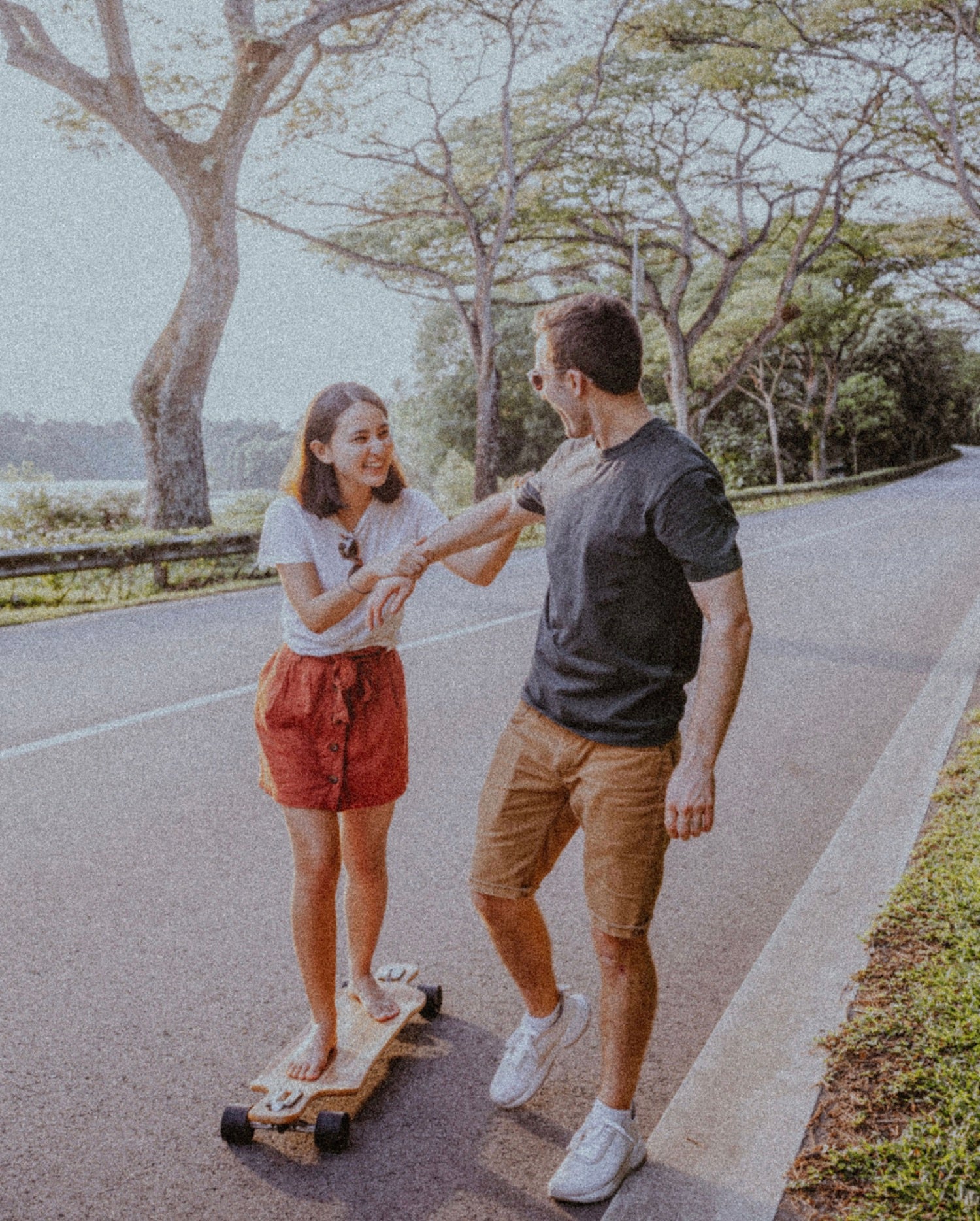 Cheap Date Ideas (That Don't Feel Cheap). Couple smiles as the guy teaches his girlfriend how to skate.