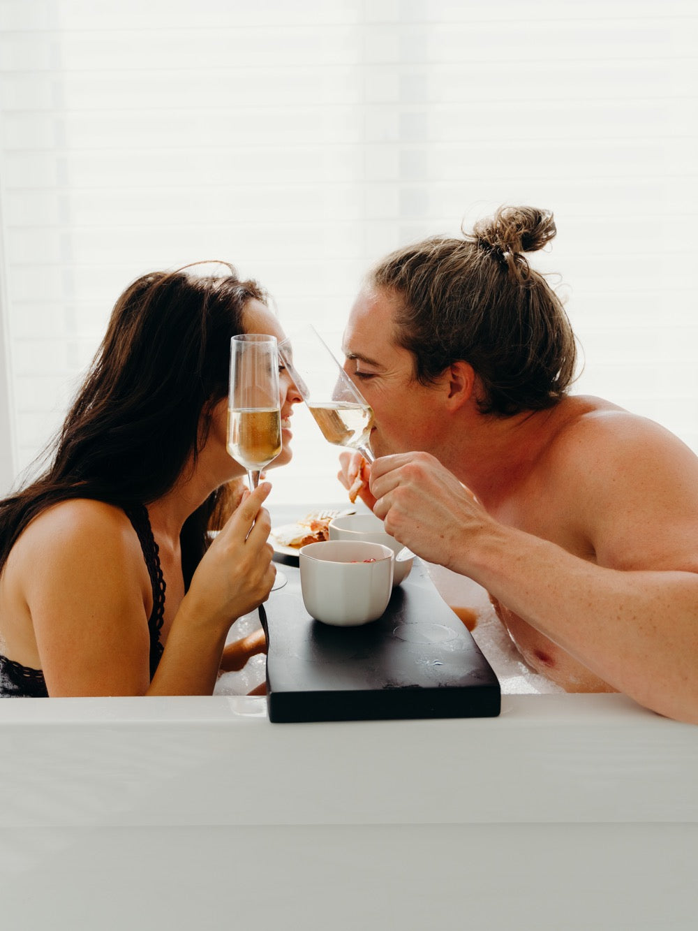 Creative, Romantic, and Fun Stay-at-Home Date Ideas for Couples: Couple share laughs in the bathtub
