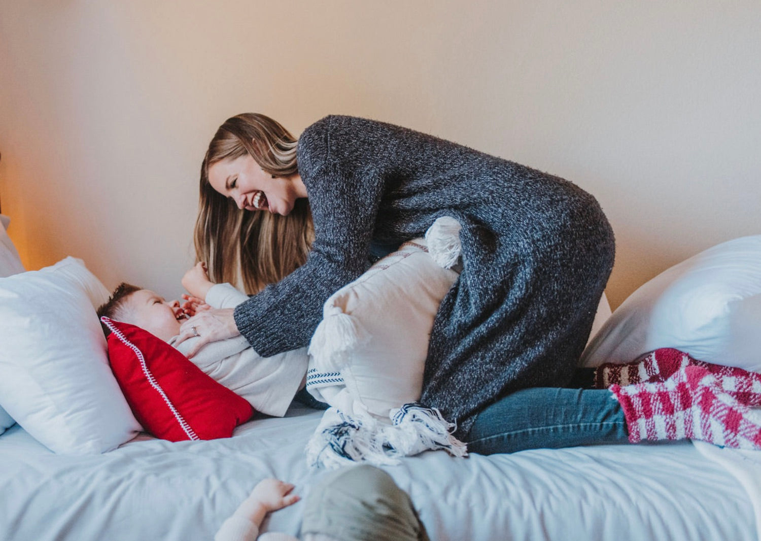 Mom tickling her son as they have fun before bedtime to make her son sleep better, a tip from The Adventure Challenge