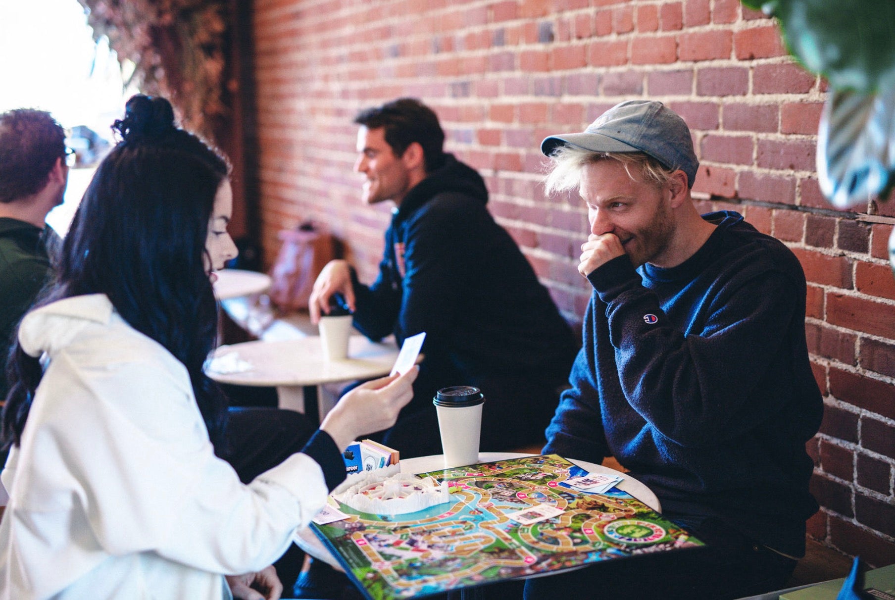 The best two play board games for couples. Couple playing board games at a cafe.
